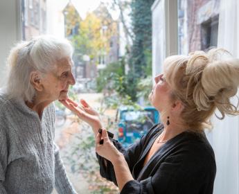 Foto van bewoner en medewerker van het Mozaïekhofje